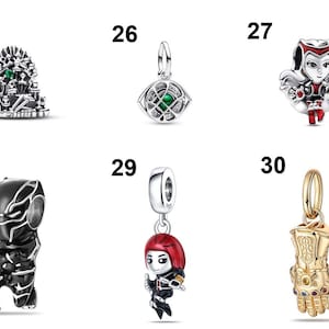May include: A collection of six silver and gold-toned metal charms labeled 25 through 30. The charms feature various character designs including a throne, an eye, a red-clad figure, a black masked figure, a red-haired figure, and a golden gauntlet.