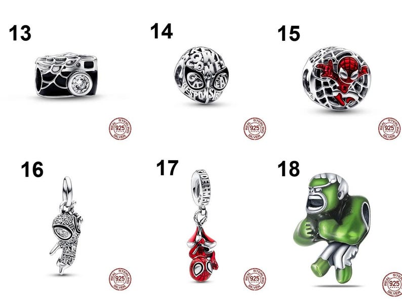 May include: A collection of six sterling silver charms featuring Marvel characters and motifs. Item 13 is a camera, 14 is a spherical charm with text, 15 is a web-patterned sphere with a red figure, 16 and 17 are hanging charms, and 18 is a green figure.