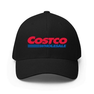 May include: Black baseball cap featuring the Costco Wholesale logo in red and blue. The logo is centered on the front of the cap. The hat has a curved brim and a structured fit.