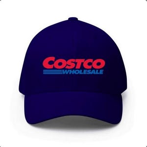 May include: A navy blue baseball cap featuring the Costco Wholesale logo in red and blue. The logo is centered on the front of the cap. The hat is a classic six-panel design.