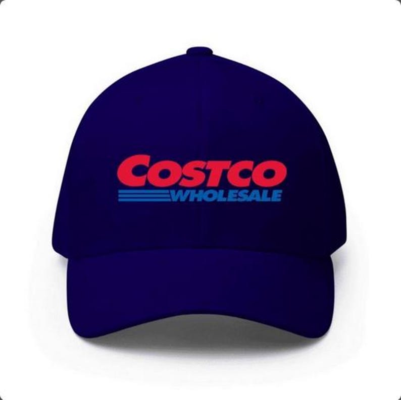 May include: A navy blue baseball cap featuring the Costco Wholesale logo in red and blue. The logo is centered on the front of the cap. The hat is a classic six-panel design.