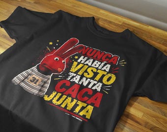 Könnte beinhalten: Ein schwarzes T-Shirt mit kurzen Ärmeln und einer Grafik einer roten Handpuppe mit langen Ohren, die ein weiß-schwarz gestreiftes Oberteil mit der Nummer 31 trägt. Der Text lautet NUNCA HABÍA VISTO TANTA CACA JUNTA in roter und gelber Schrift.