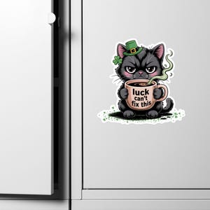 Op de afbeelding: Een witte keramische mok met een zwart handvat en de tekst "But First, Coffee" in een zwarte, handgeschreven lettertype. De mok staat op een wit oppervlak.