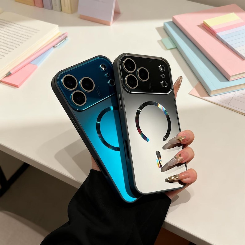 May include: Two smartphone cases, one blue and one silver, are displayed. The blue case has a gradient effect, transitioning from dark blue to a bright turquoise. The silver case has a reflective surface. Both cases have a circular design.