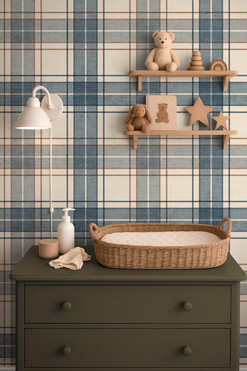 Puede incluir: Una escena de guarder&iacute;a con una c&oacute;moda verde, una cesta para cambiar pa&ntilde;ales de mimbre y una l&aacute;mpara de pared blanca. Estantes exhiben un oso de peluche, un conejito, juguetes de madera y una estrella. El fondo es un papel pintado a cuadros azul y blanco.