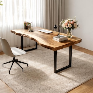 以下が含まれることがあります： 黒い金属製の脚が付いた、自然な木端の木製デスク。左側には白いオフィスチェアがあります。花瓶、デスクランプ、文房具がデスクの上にあります。デスクはベージュのラグの上にあります。