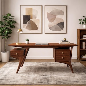 May include: A mid-century modern wooden desk with two drawers, a gold lamp, and a laptop. Two abstract art pieces hang on the wall above the desk. A potted plant and a small bookshelf are also in the room. The desk is approximately 60 inches wide.