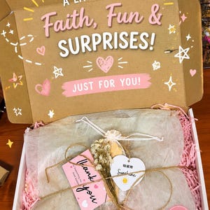 May include: A gift box with the text "A Little Box of Faith, Fun & Surprises!" and "Just for You!" The box contains wrapped items, a "Thank You" tag, and a heart-shaped tag that says "You are my Sunshine."