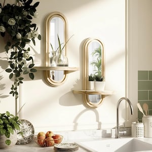 May include: Two wooden wall mirrors with shelves, each featuring an arched top and a half-circle mirror below. One holds a vase with greenery, the other small potted plants. The mirrors are mounted on a light-colored wall.