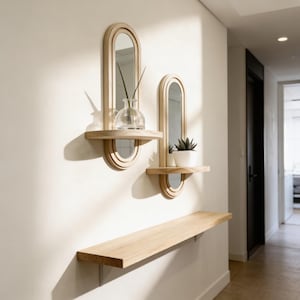 May include: Two wooden wall mirrors with shelves, each featuring an oval mirror and a small shelf. One shelf holds a clear glass vase with a plant, and the other holds a small potted succulent. A long wooden shelf is mounted below.