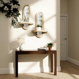 May include: Two arched wall mirrors with attached shelves, each holding a small plant. A dark brown console table with a white lamp and a potted plant sits below. A white door is visible in the background.