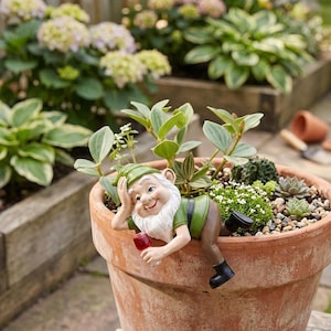 May include: A garden gnome figurine with a white beard, green hat, green shirt, and brown pants, reclining on the rim of a terracotta pot. The gnome holds a small glass of red liquid in one hand while resting the other hand against its head.