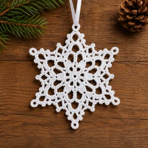 May include: A white crocheted snowflake ornament featuring an intricate, symmetrical lace pattern with six points. The ornament is suspended by a thin white ribbon loop, showcasing delicate thread work and a complex geometric design.