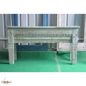 以下が含まれることがあります： 上部と脚に複雑な彫刻が施された、使い古された水色の木製コンソールテーブル。 テーブルは長方形で、4本の頑丈な脚の上に立っています。 木材は風化した外観をしています。 テーブルの長さは約152cmです。