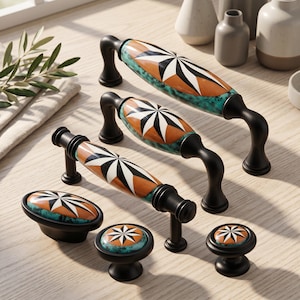May include: A collection of cabinet hardware including three arched handles and three knobs with matte black metal bases. Each piece features a central ceramic inlay with a starburst pattern in orange, black, and white, surrounded by a teal marbled border.