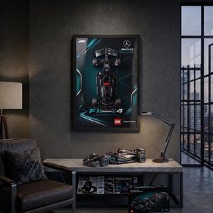 Könnte beinhalten: Ein gerahmtes Poster mit einer Draufsicht auf einen schwarzen Mercedes-AMG Petronas Formel-1-Wagen mit türkisfarbenen Akzenten, dem F1-Logo und LEGO Technic-Branding. Darunter steht ein LEGO Technic-Modell des Wagens auf einem grauen Tisch.
