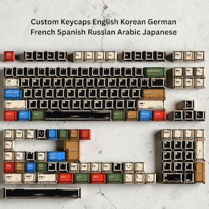 May include: Custom keycaps in various colors and designs, including English, Korean, German, French, Spanish, Russian, Arabic, and Japanese layouts. The keycaps are arranged to resemble a keyboard, with a variety of symbols and characters.