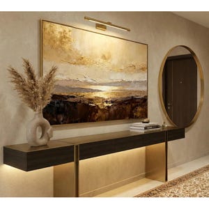 Peut inclure: Une entrée moderne avec une console en bois foncé, des accents dorés et une grande peinture abstraite aux tons or et beige. Un miroir rond doré et un vase décoratif avec des plantes séchées complètent le décor.