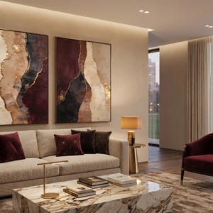 May include: Two large rectangular wall art pieces featuring abstract layers of cream, deep burgundy, black, and metallic gold paint. The textured canvases are displayed side-by-side, showcasing organic, flowing shapes and bold color contrasts.