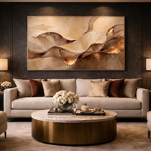 Peut inclure: Un salon luxueux avec une grande peinture abstraite aux tons or et marron au-dessus d'un canapé crème. La pièce comprend deux fauteuils, une table basse ronde et deux lampes.