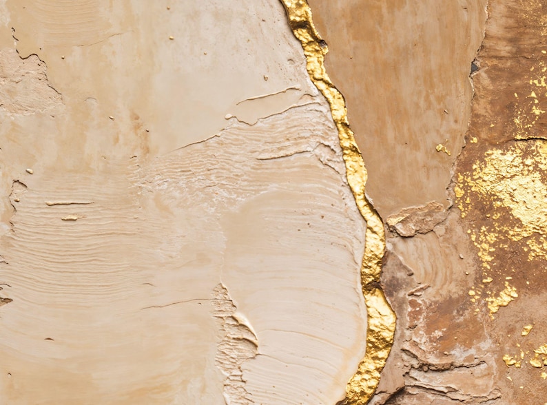 May include: An abstract painting featuring thick, textured layers of beige and tan paint. A prominent, jagged vertical line of metallic gold leaf runs through the center, with additional gold leaf accents scattered on the right side of the canvas.