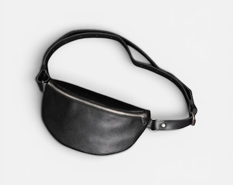 Riñonera minimalista de cuero negro hecha a mano con forma de media luna.