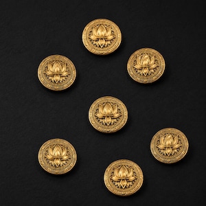 May include: Seven antique gold-coloured buttons featuring a lotus flower design. Each round button has a detailed floral pattern in the centre and a decorative border. The buttons are arranged on a black surface.
