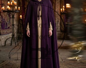 Puede incluir: Una capa con capucha de color morado intenso que llega hasta el suelo, con cierre de lazo en el cuello y aberturas para los brazos. La capa se lleva sobre una prenda larga de color beige de manga larga con un escote sencillo y opaco.