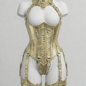 Peut inclure: Un corset doré avec un motif peau de serpent, comprenant un col montant, des bretelles et des jarretelles. Le corset comporte plusieurs boucles et des éléments métalliques. Le vêtement est présenté sur un mannequin blanc.