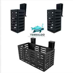 Pode incluir: Três acessórios de aquário de plástico preto. Dois são retangulares com um clipe e um é uma cesta retangular com dois clipes. O logotipo da Terraloo está no centro da imagem.