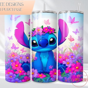 May include: A cylindrical tumbler featuring a blue alien character with large ears wearing a pink and purple flower crown, surrounded by pink and purple flowers and butterflies against a light blue sky background, with a clear straw and lid.
