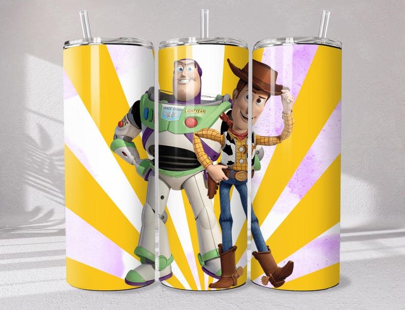 May include: A cylindrical stainless steel tumbler with a clear lid and straw, featuring a vibrant yellow and white sunburst background pattern. The design displays the characters Buzz Lightyear and Woody from Toy Story standing side by side.