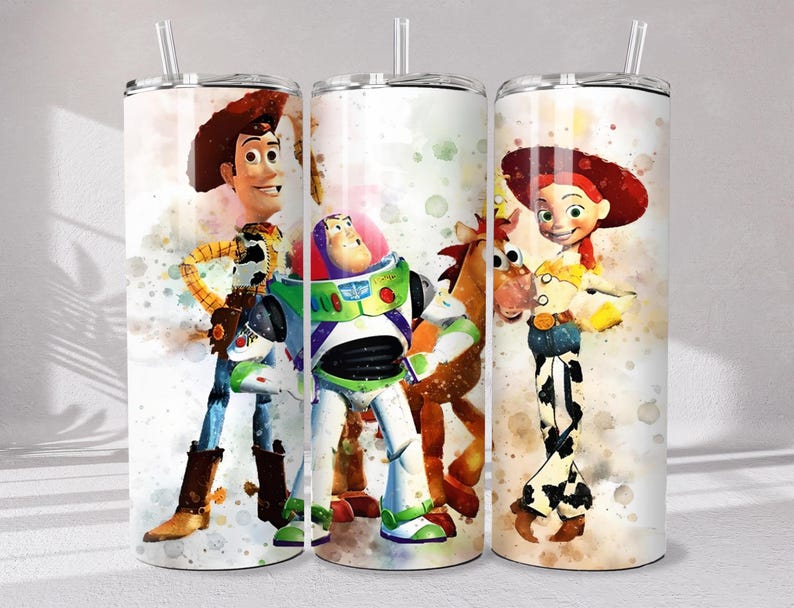 May include: Three cylindrical tumblers with clear plastic straws, each featuring a watercolor-style print of Toy Story characters including Woody, Buzz Lightyear, Bullseye, and Jessie against a white background with colorful paint splatters.