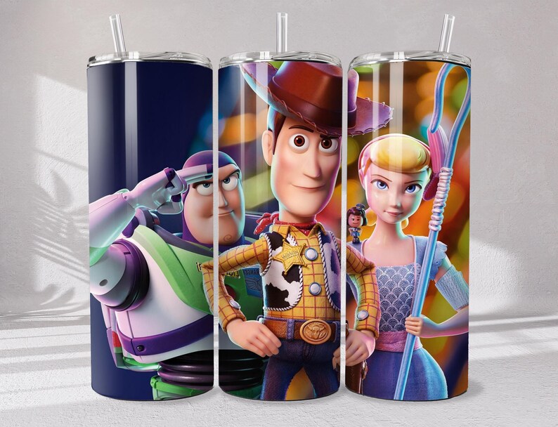 May include: A cylindrical tumbler with a clear straw featuring a wrap-around graphic of Toy Story characters including Buzz Lightyear, Woody, and Bo Peep. The design displays Buzz in a salute, Woody in his cowboy attire, and Bo Peep holding her staff.