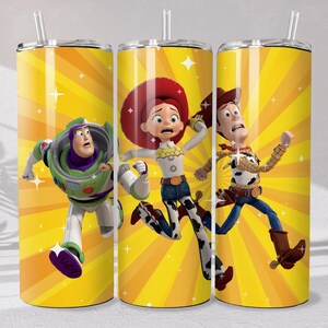 May include: A cylindrical tumbler with a straw featuring a bright yellow background with radiating sunburst lines and white sparkles. The design displays three animated characters in motion, including a space ranger and two cow-themed figures.