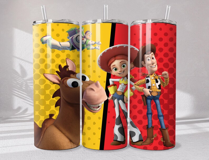 May include: Three cylindrical tumblers with clear lids and straws. The left tumbler features a yellow background with polka dots, Bullseye the horse, and Buzz Lightyear. The right tumbler has a red background with polka dots, Jessie, and Woody.