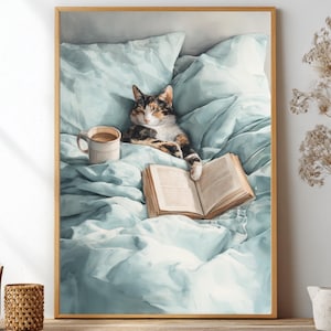 May include: A framed print showing a cat relaxing in bed with a book and a coffee cup. The cat has brown, black, and white fur. The bed linen is light blue, and the book is open. A comfortable, cosy scene.