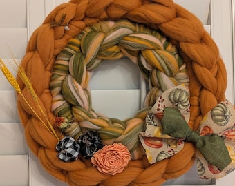 Couronne artisanale en grosse laine ornée de motifs botaniques de saison