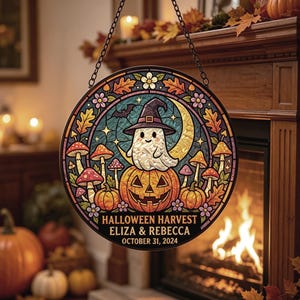 Puede incluir: Un letrero colgante circular con diseño estilo vitral que muestra un fantasma con sombrero de bruja sobre una calabaza, rodeado de setas y hojas de otoño. El texto dice HALLOWEEN HARVEST ELIZA & REBECCA OCTOBER 31, 2024.