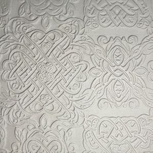 May include: A white surface featuring a repeating embossed pattern of intricate, interconnected knotwork and swirling organic shapes. The design consists of raised lines that create a textured, three-dimensional effect across the entire flat plane.