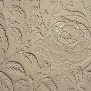 May include: A neutral-toned floral pattern with embossed rose blooms and leaves. The design creates a three-dimensional effect. The pattern is detailed and elegant, suitable for various decorative applications.