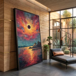 Puede incluir: Un gran cuadro rectangular enmarcado que muestra un vibrante eclipse solar sobre una masa de agua tranquila. El cielo está lleno de tonos arremolinados de rojo intenso, naranja y morado, mientras que el agua refleja los colores intensos del evento.