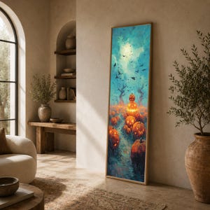 Op de afbeelding: Een hoog, rechthoekig ingelijst kunstwerk aan de muur met een veld van gloeiende oranje pompoenen onder een donkerblauwe lucht vol silhouetten van vliegende vleermuizen en een heldere maan, geplaatst tegen een lichte muur.