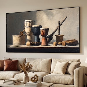 May include: A framed still-life painting depicting a selection of drums and percussion instruments. The drums are of various sizes and colours, including natural wood, black, and red. The artwork hangs above a beige sofa, adding a touch of musical theme.