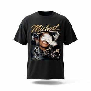 May include: Black t-shirt featuring a gold-colored "Michael" text and a collage of images of Michael Jackson. The collage includes images of him wearing a hat, a white glove, and performing on stage. The shirt has a crew neck.