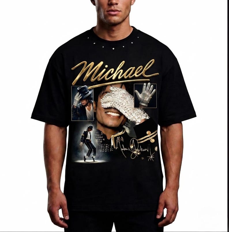 May include: Black t-shirt featuring a gold script of the name "Michael" above a collage of images. The collage includes a portrait, a glove, and a dancing figure. The shirt also has the signature "Michael Jackson" in gold.