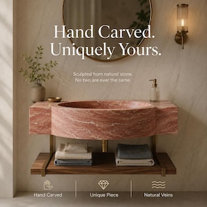 Puede incluir: Un lavabo de ba&ntilde;o de m&aacute;rmol rosa con cuenco circular, montado sobre un estante de madera oscura con toallas dobladas. El texto dice: Hand Carved. Uniquely Yours. Sculpted from natural stone. No two are ever the same. Hand Carved, Unique Piece, Natural Veins.