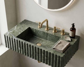 Lavabo scanalato in marmo verde intagliato a mano, con mobiletto integrato in pietra.