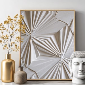May include: A framed, textured white wall art with a gold frame. A gold vase with dried flowers, a small brown vase, and a white Buddha head are in front of the art piece. The art piece has a geometric design.
