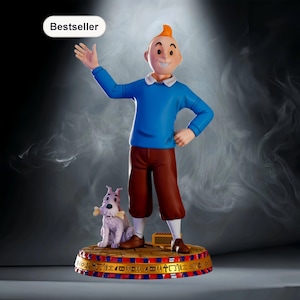 May include: A figurine of a cartoon character with orange hair wearing a blue sweater and brown pants, standing next to a small white dog holding a bone. The base is circular with gold and red patterns and the text Bestseller is visible above.